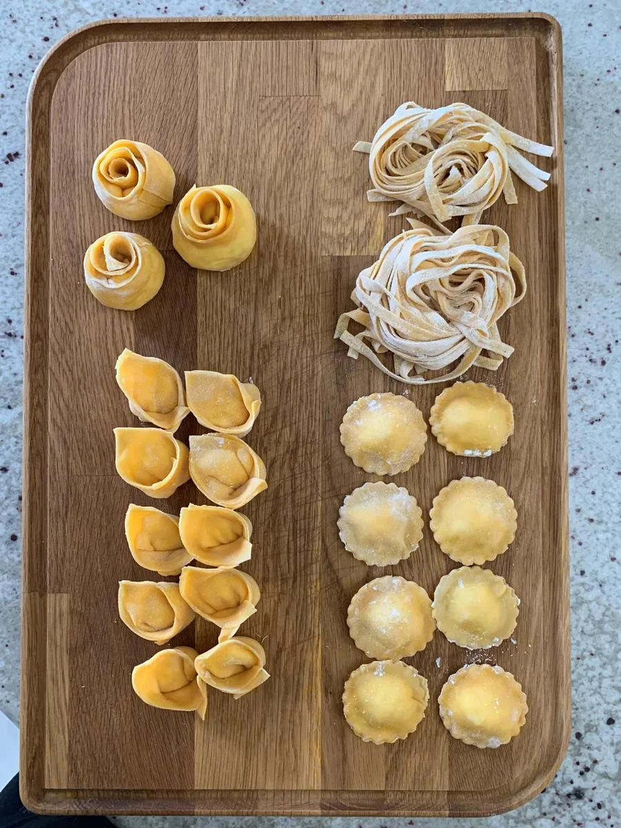 Rosas de tortellini, cappelletti, tagliatelle y ravioli, dispuestos sobre la tabla