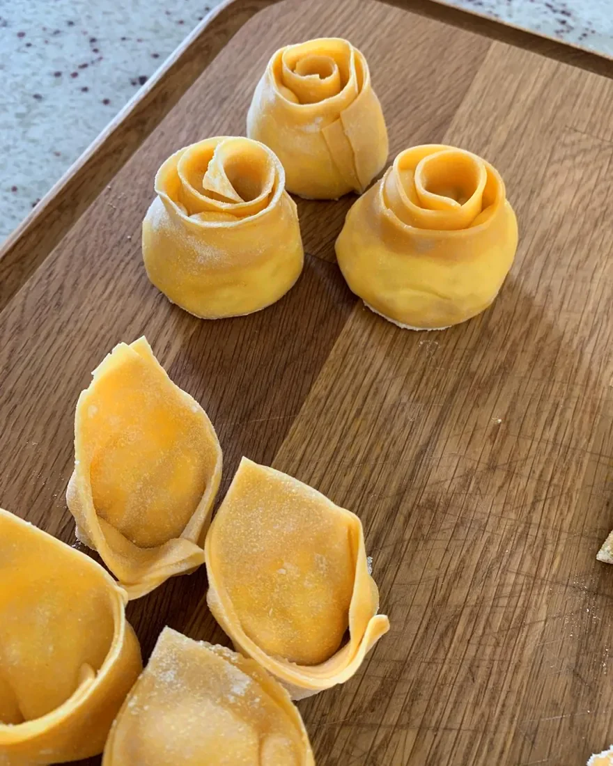 Rosas de tortellini y cappelletti hechos a mano, sobre la tabla