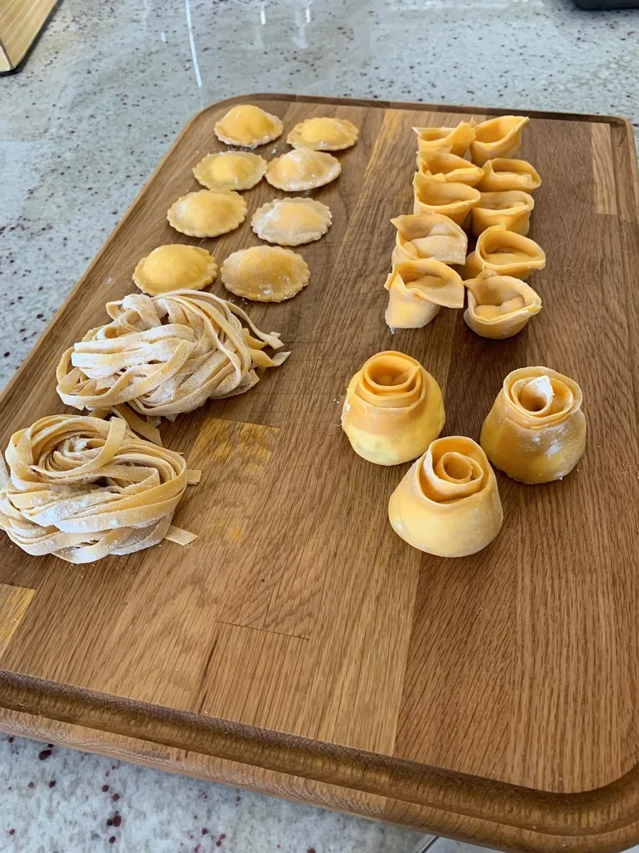 Nidos de tagliatelle junto a rosas de tortellini